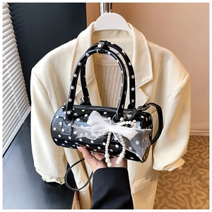 Détail du sac cylindre à pois avec nœud en dentelle et perles pour femmes