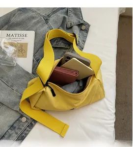 Spacious yellow crossbody bag interior holding a smartphone, long wallet, and folding umbrella