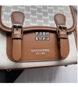 Vue macro d'un sac messager vintage montrant la texture du cuir et les boucles argentées