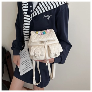 Detail of cream white quilted PU leather mini backpack with macaron beaded handle chain