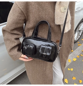 Glossy black crossbody bag with dual functional exterior pockets and adjustable strap