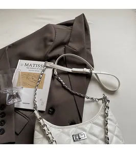 Detail des verstellbaren Kettenriemens und Drehverschlusses der weißen Stepptasche