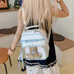 Détail du sac ITA blanc et bleu avec fenêtre transparente présentant des badges anime