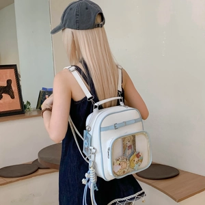 Détail du sac ita blanc avec bordure bleu clair et poche transparente pour pins et cartes