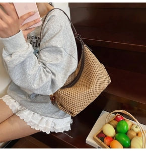 Gros plan du sac en paille tressée avec bandoulière en cuir marron et perles de bois