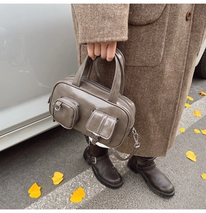 Close-up of gloss leather finish on a retro tote bag with functional exterior pockets