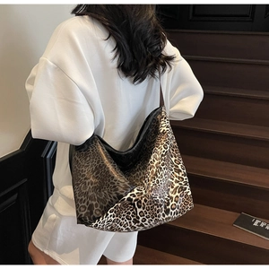 Close-up of a large leopard print tote bag styled with a minimalist white casual outfit