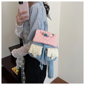 Detail of multi-color quilted backpack with bead charms and branded LULU flap logo