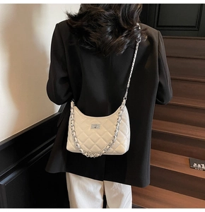 Nahaufnahme der weißen gesteppten Hobo-Tasche mit silberner Kette und Drehverschluss