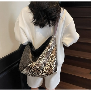Back view of a large leopard print crossbody bag showing size and fit on a model