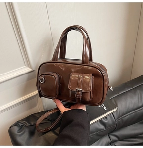 Detailed close-up of a vintage brown leather pillow bag featuring multi-pocket design details