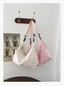 Detail der Crossbody-Tasche mit Waffelstruktur in Creme und Rosa mit verstellbarem Gurt