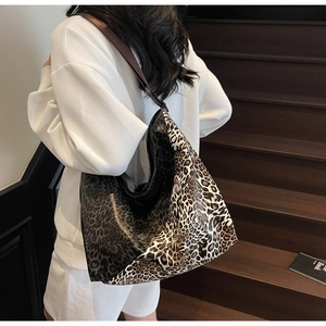 Detailed back view of a large leopard print hobo bag with wide brown shoulder strap