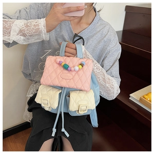 Detail of color-block mini backpack with quilted flap and colorful beaded top handle
