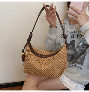 Détail du sac demi-lune en paille tressée avec bandoulière en cuir et perles colorées