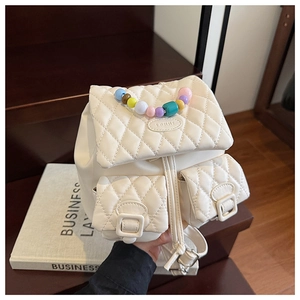 White quilted mini backpack featuring colorful beaded handle and classic diamond pattern