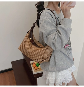 Détail du sac à bandoulière en paille tressée avec bandoulière en cuir et perles vintage
