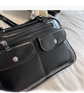 Detail showing high-shine black bowling bag fabric with vintage silver buckles