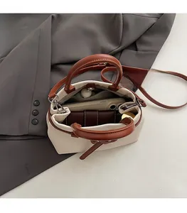 Internal view of a canvas bucket bag showing capacity for phone and wallet with leather trim