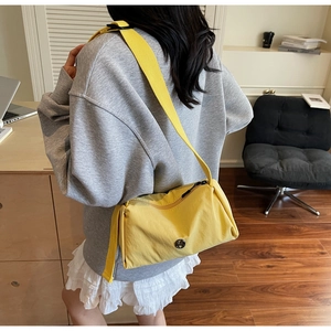 Macro detail of yellow nylon crossbody bag with zipper and adjustable wide strap
