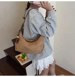 Détail du sac à bandoulière en paille tissée avec perles d'ambre et lanière en cuir