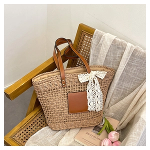 Macro detail of straw woven texture with leather patch and white lace bow on tote bag