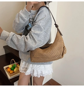 Détail du sac hobo tissé en paille montrant la texture maille et la bandoulière nouée