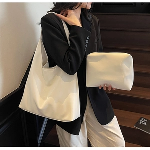 Detail showing white minimalist tote bag set with matching pouch on a stylish model