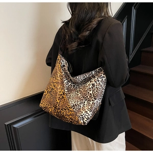 Detailed view of large leopard print hobo bag worn with a black blazer on a model