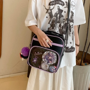 Détail du sac ita noir et violet avec fenêtre transparente et pin's décoratifs