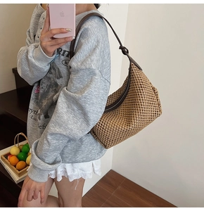 Détail du sac hobo en paille tissée main avec fermeture éclair et bandoulière en cuir