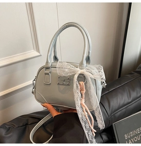 Detail der hellblauen Boston Bag mit Spitzen-Schleife und verstellbarem Schultergurt
