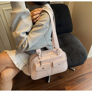 Detail view of pink vintage tote bag with buckle pockets and smooth faux leather texture