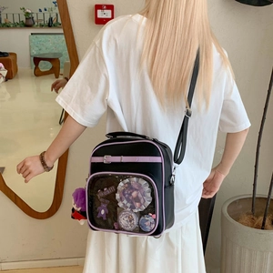 Détail d'un sac ita violet et noir montrant la fenêtre transparente et les gris-gris
