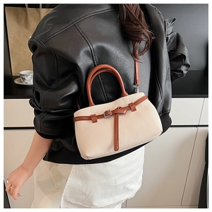 Detail of woven fabric texture and brown leather strap on a stylish bucket bag