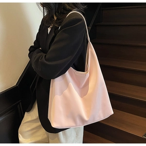 Detail of a large light pink tote bag with soft glossy finish and minimalist design