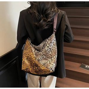Detailed view of leopard print tote bag featuring an adjustable wide shoulder strap