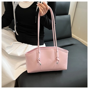 Close-up of pink faux leather tote bag with unique knot shoulder strap and silver metal tips