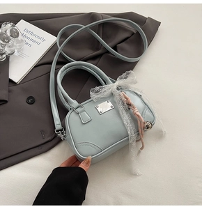 Hellblaue Bowlingtasche aus mattem Leder mit Spitzenschleife und silberner Logo-Plakette