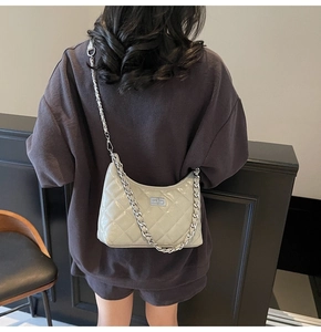Detail der hellbeigen Stepptasche mit silbernem Drehverschluss am Model