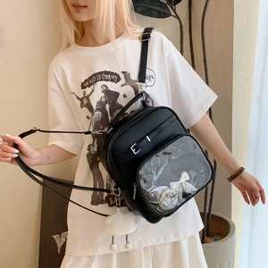 Détail du sac Ita noir avec fenêtre transparente, nœud et breloque nuage en peluche