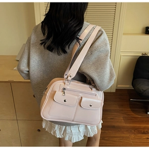 Detail of light pink patent leather bowling bag with silver hardware and front pockets