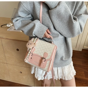 Détail du sac à bandoulière rose et blanc avec breloque ours et ruban de soie