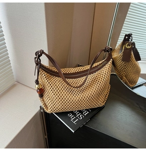 Détail du sac bandoulière en paille tressée avec garniture en cuir brun et fermeture éclair