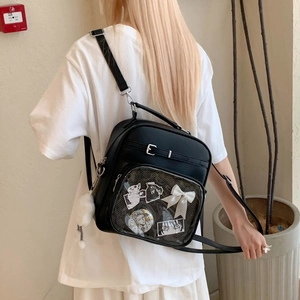 Vue détaillée du sac Ita noir avec fenêtre transparente et badges d'anime