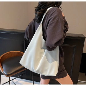 Macro detail of high-quality white hobo bag showing soft matte texture and seamless shoulder strap