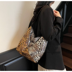 Lifestyle shot of large leopard print patchwork tote bag on shoulder with dark leather strap