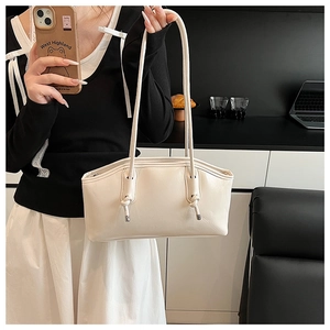Detail of cream white shoulder bag featuring unique knotted straps and metallic accents