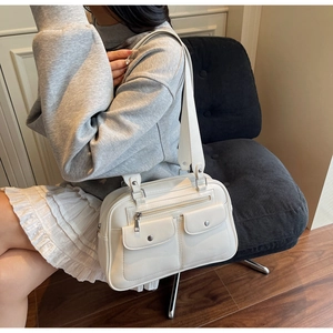 Close-up of white retro tote bag featuring double front flap pockets and metal hardware