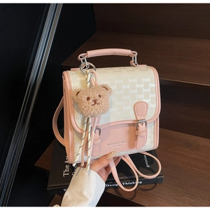 Détail d'un mini sac à dos rose et beige avec un charmant porte-clé en ours en peluche